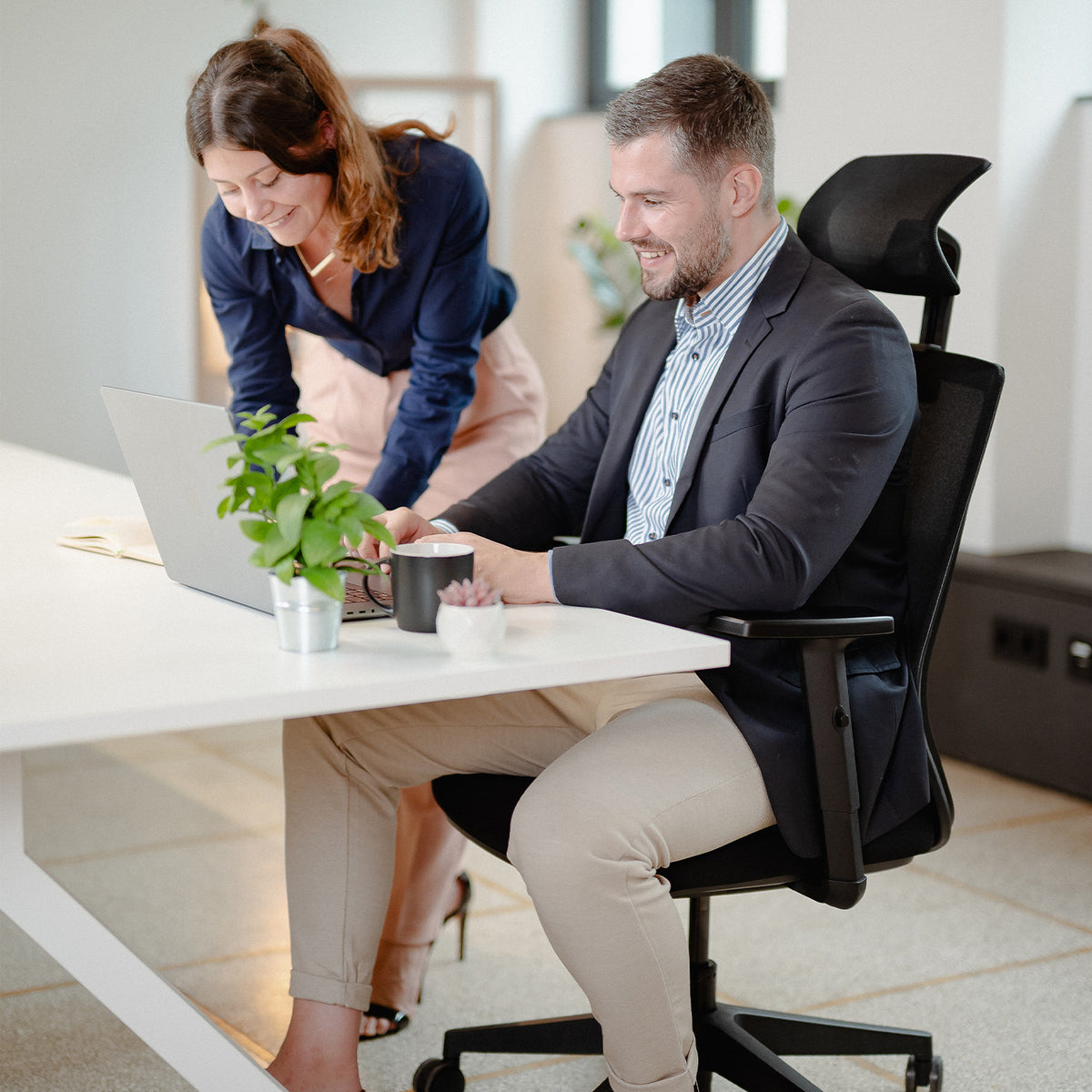 Kollegen arbeiten an Schreibtischen in ergonomischen VALKENSTOL M3 Bürostühlen