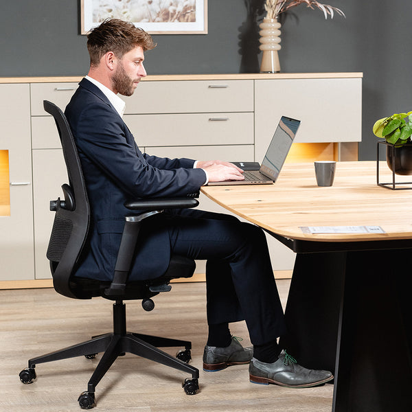 Mann arbeitet am Schreibtisch im VALKENSTOL M4 Bürostuhl